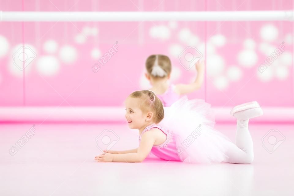 Bambina ballerina in un tutù rosa. Adorabile bambino che balla balletto classico in uno studio bianco. I bambini ballano. L'esecuzione di bambini. Giovane ballerina di talento in una classe. Kid prescolare prendere lezioni d'arte.