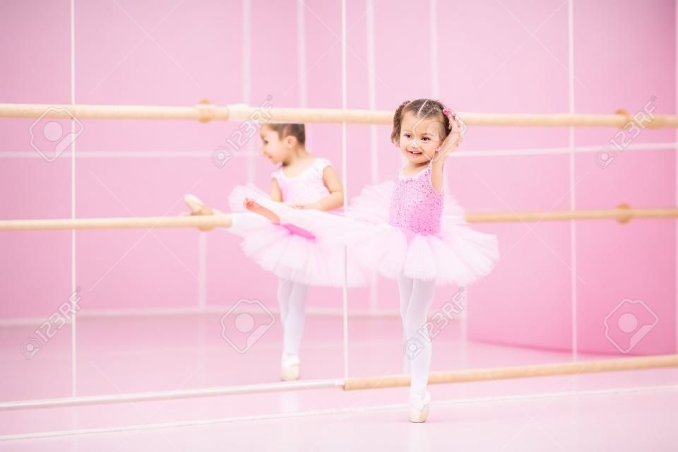 Mała baleriny dziewczyna w różowym tutu. Adorable dziecko tańczy balet klasyczny w studiu białego. Dzieci tańczą. Dzieci wykonywania. Młody utalentowany tancerz w klasie. Przedszkole dzieckiem lekcje sztuki.