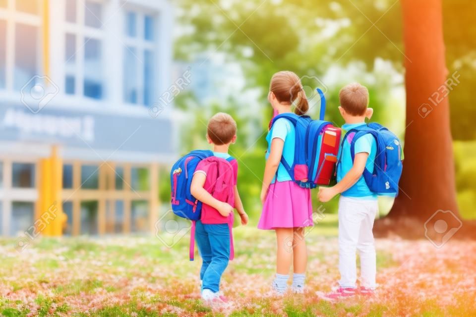 Dzieci wracają do szkoły. początek nowego roku szkolnego po wakacjach. chłopiec i dziewczynka z plecakiem i książkami na pierwszy dzień w szkole. początek zajęć. edukacja dla przedszkolaków i dzieci w wieku przedszkolnym.