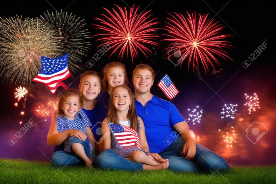 American family celebrating Independence Day. Picnic and fireworks on 4th of July in America. USA flag. Parents and kids celebrate US holiday. children watching fireworks.