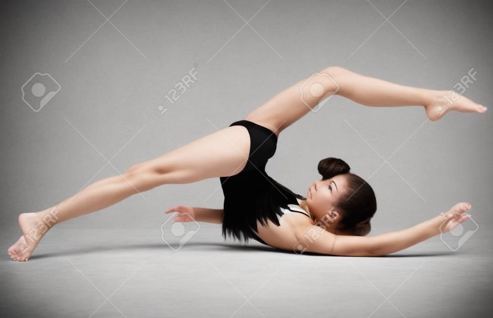 Fille gymnaste dans flexible arrière pose sur blanc