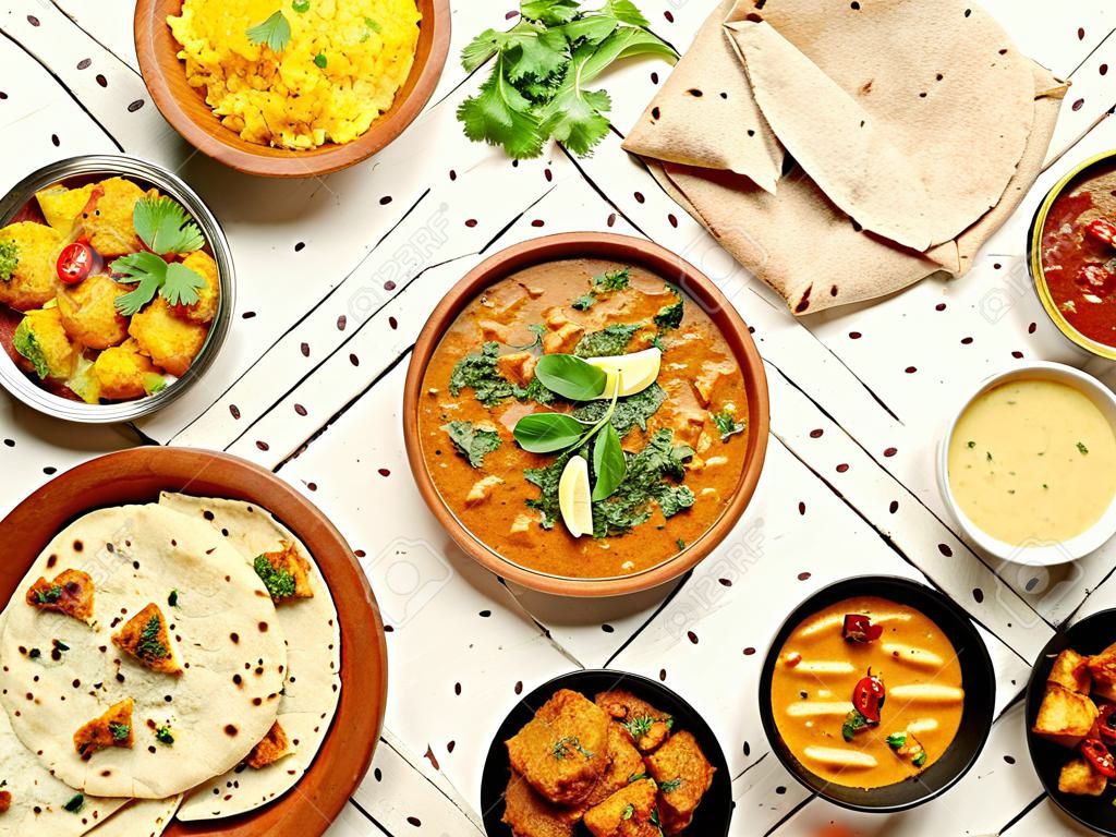 인도 요리: 티카 마살라, 달, 파니르, 사모사, 차파티, 처트니, 향신료. 흰색 나무 배경에 인도 음식입니다. 텍스트 복사 공간이 있는 다양한 인도 식사. 평면도 또는 평면도.