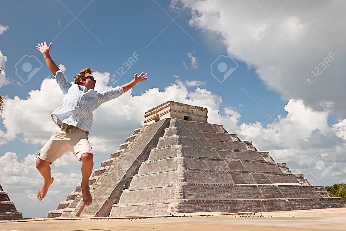 Heureux jeune homme sauter de bonheur près d'une pyramide à Tulum, au Mexique.