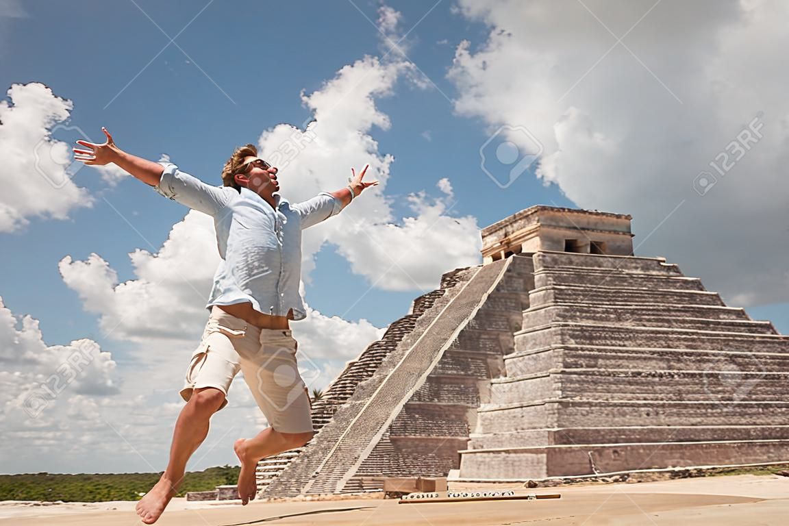 Happy młody człowiek skoki szczęścia w pobliżu piramidy w Tulum, Meksyk.