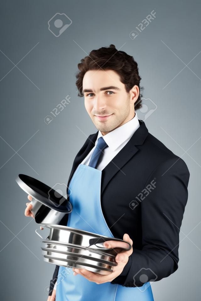 homme en costume avec un tablier tenant un pot de cuisson