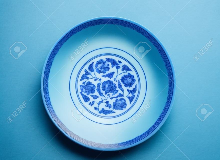 Directly above an empty blue china bowl