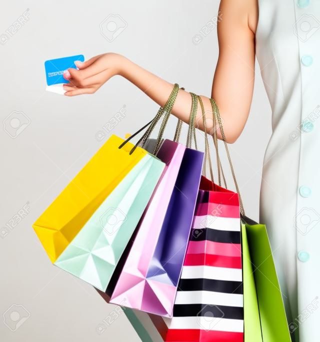 Cerca de mano de la mujer con bolsas de tiendas, comercios y tarjetas de crédito
