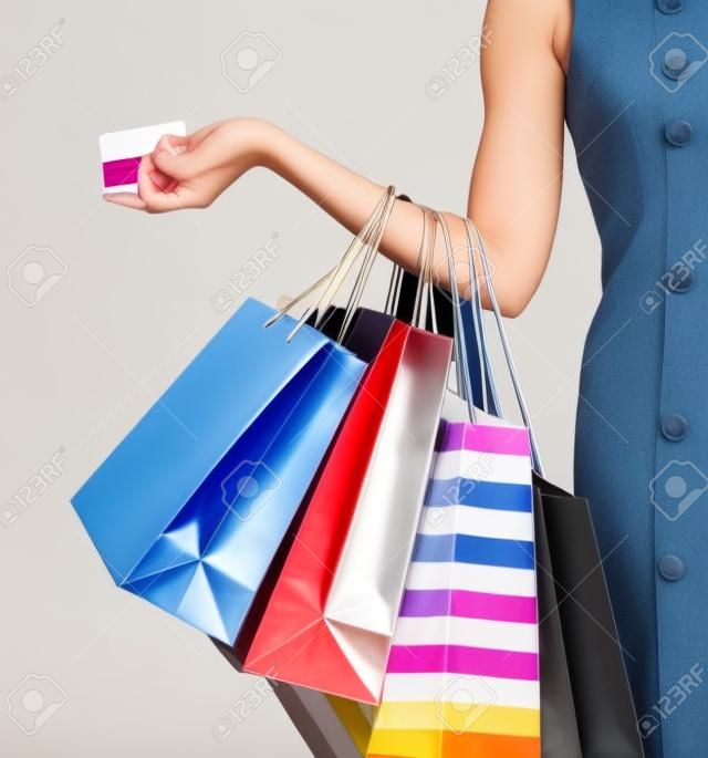 Cerca de mano de la mujer con bolsas de tiendas, comercios y tarjetas de crédito
