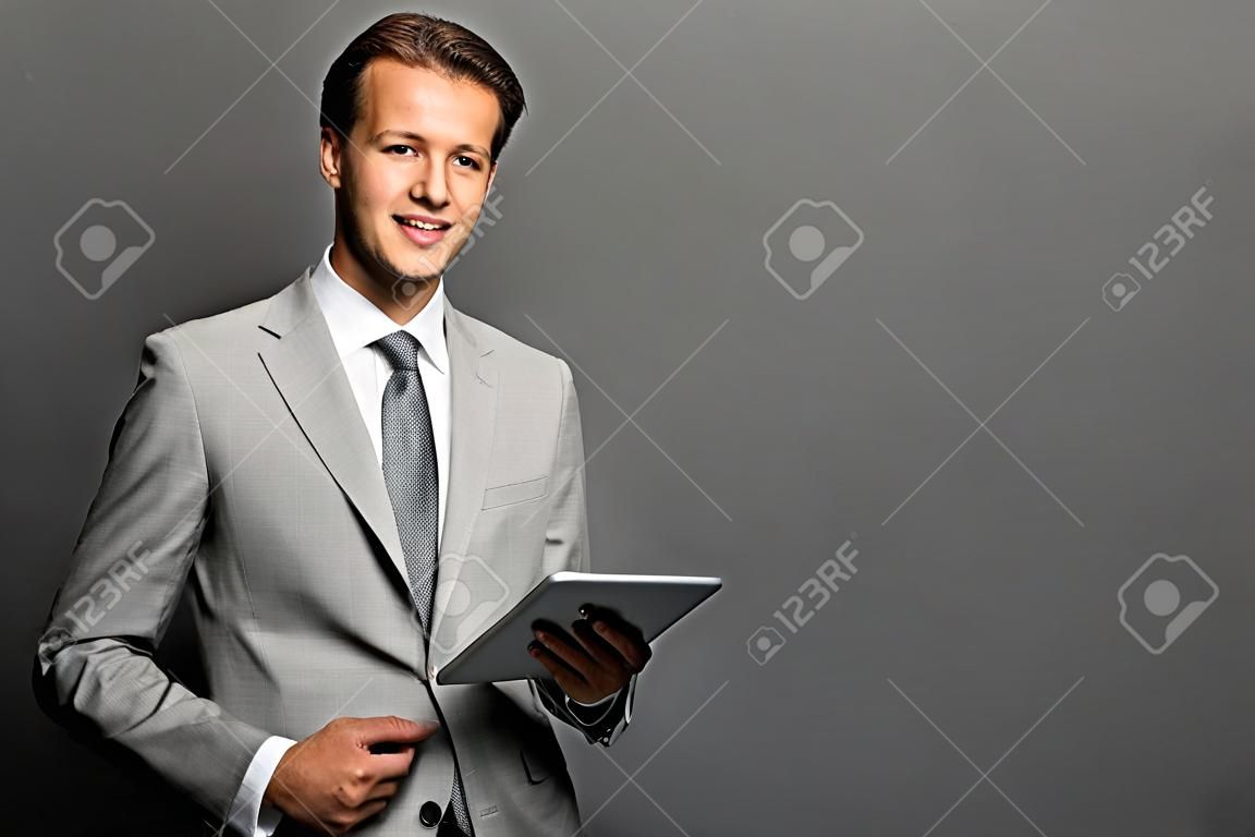 태블릿 성공적인 유럽 비즈니스 남자의 초상화는 검은 배경 위에 절연