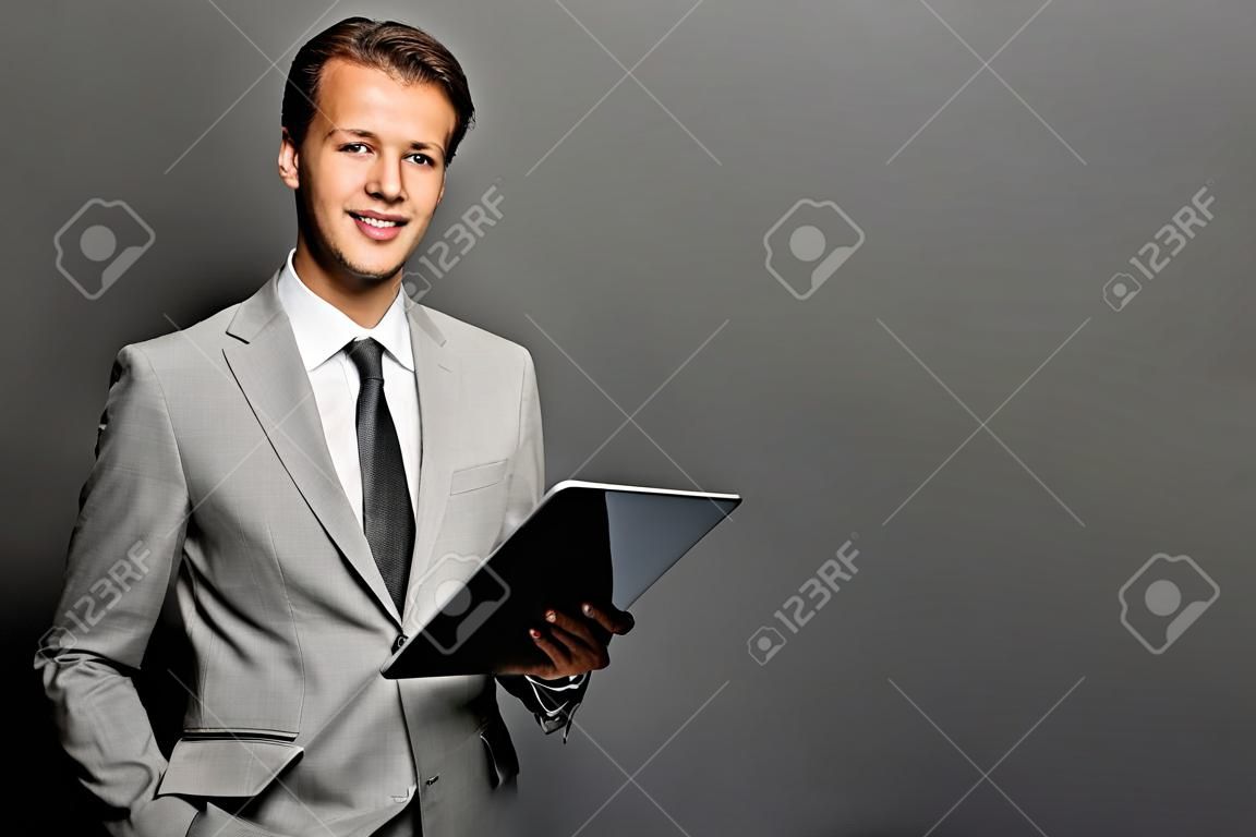 태블릿 성공적인 유럽 비즈니스 남자의 초상화는 검은 배경 위에 절연