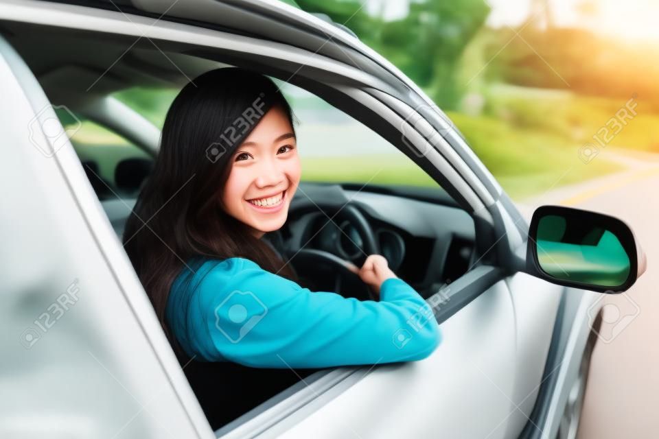 A portrait of a happy young asian woman riding a car