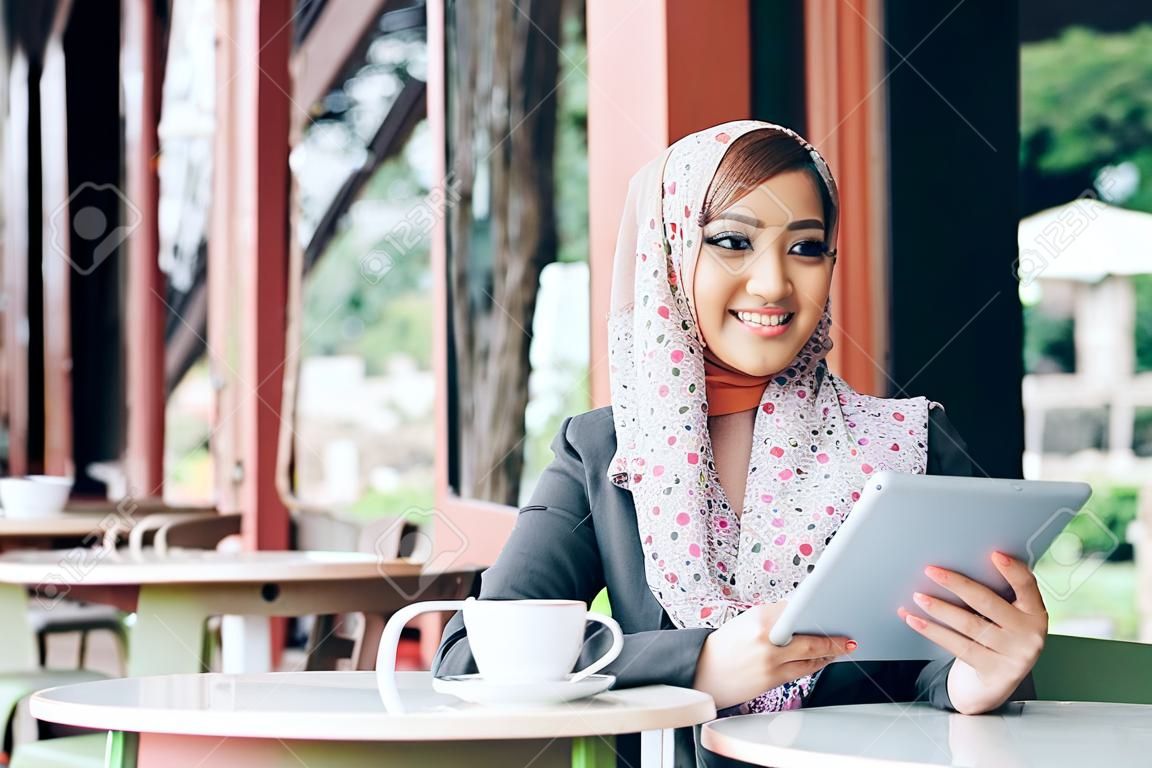 Young businesswoman on a coffee break. Using tablet computer