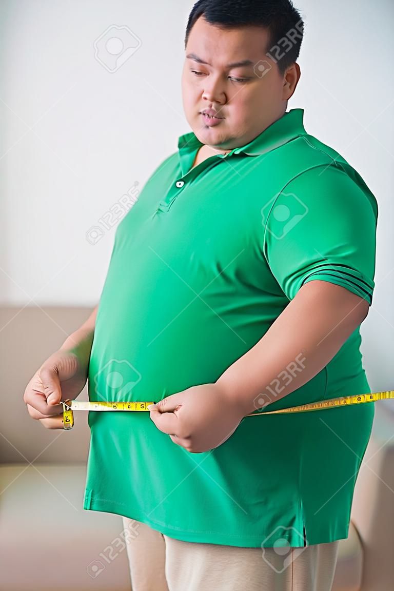 自宅に彼の腹を測定太りすぎの男性の肖像画