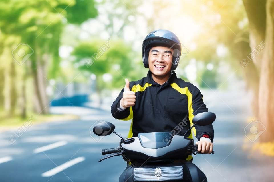ritratto di felice uomo asiatico lavoro come un conducente motociclista commerciale mostrando i pollici fino alla fotocamera
