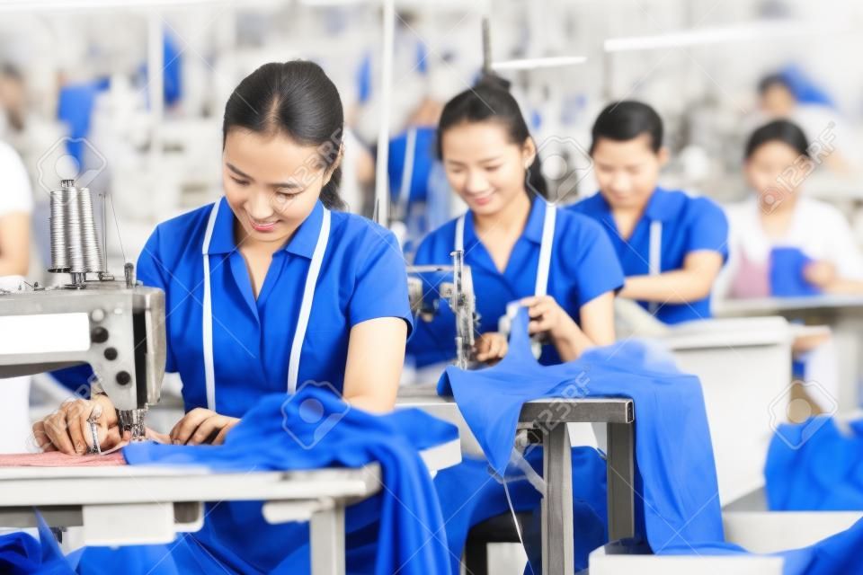 工業用縫製で縫製する衣料品工場のアジア人労働者