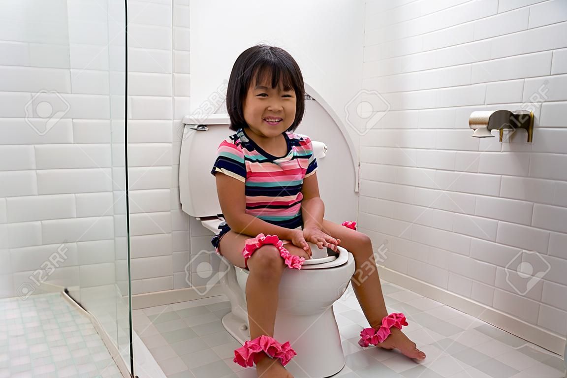 enfant assis et apprenant à utiliser les toilettes