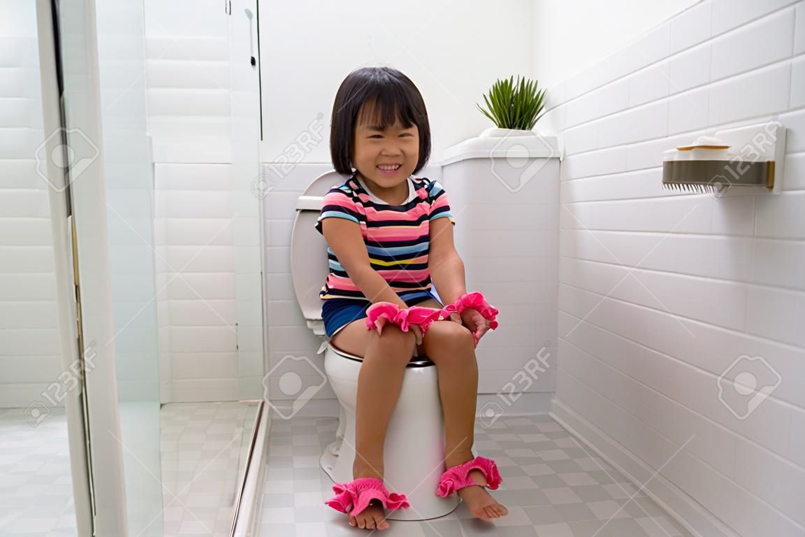 child sitting and learning how to use the toilet