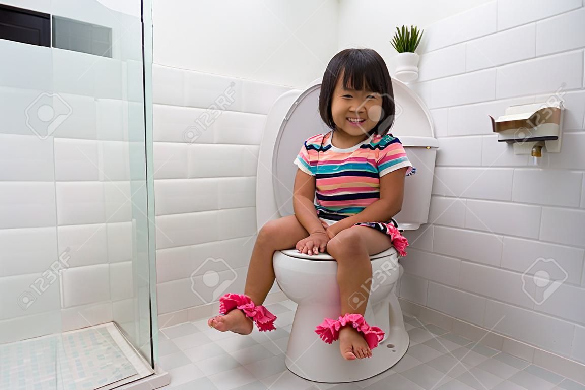 enfant assis et apprenant à utiliser les toilettes