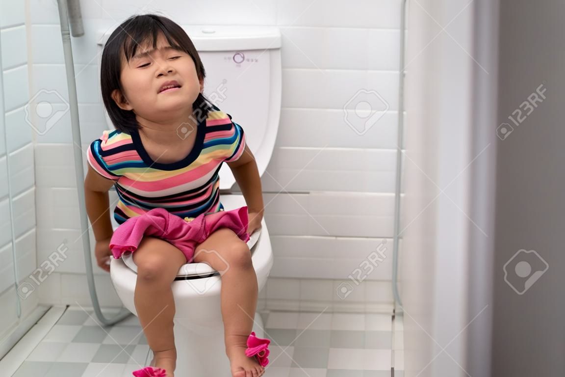 아시아 아이는 화장실에 앉아있는 동안 그것을 세게 밀어