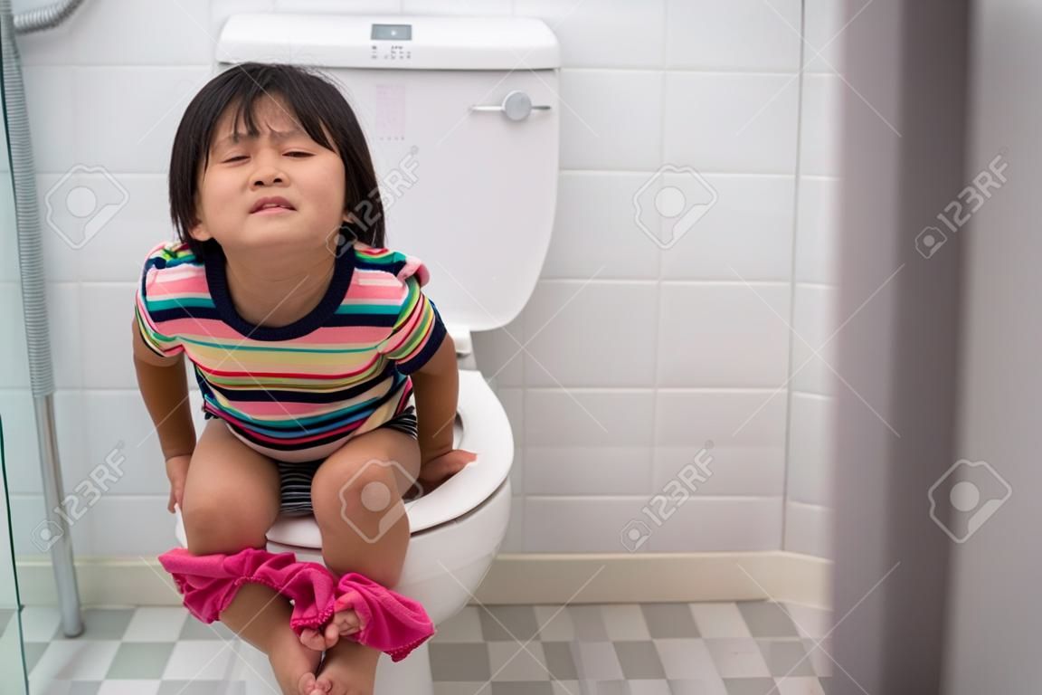 아시아 아이는 화장실에 앉아있는 동안 그것을 세게 밀어