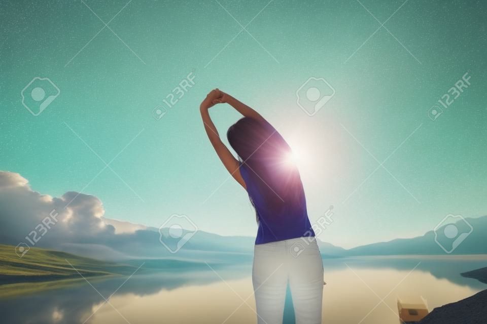 woman enjoy the morning and raise arm