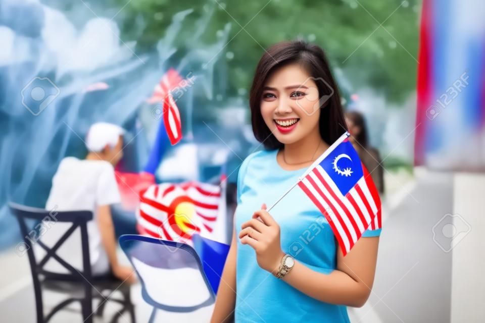 asiatische Frau mit Malaysia-Flagge beim Feiern des Unabhängigkeitstages