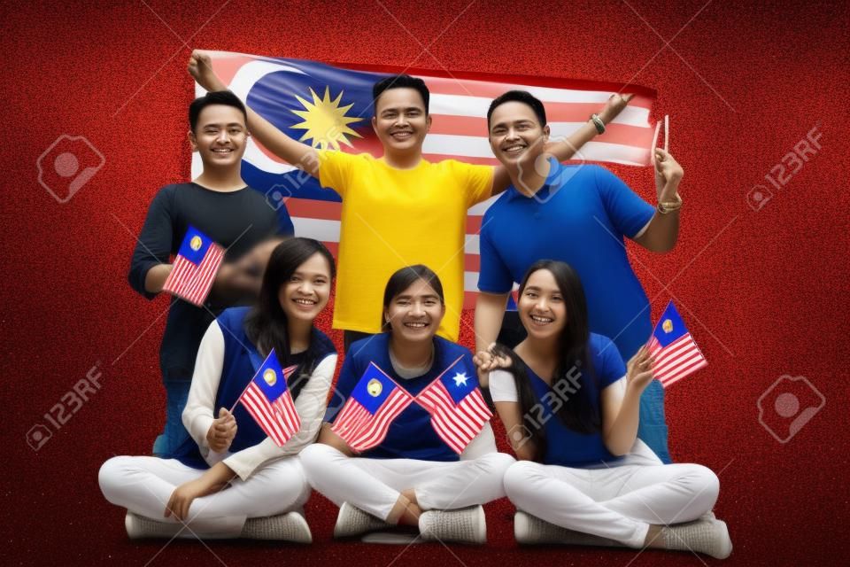Pessoas segurando bandeira da Malásia comemorando o dia da independência