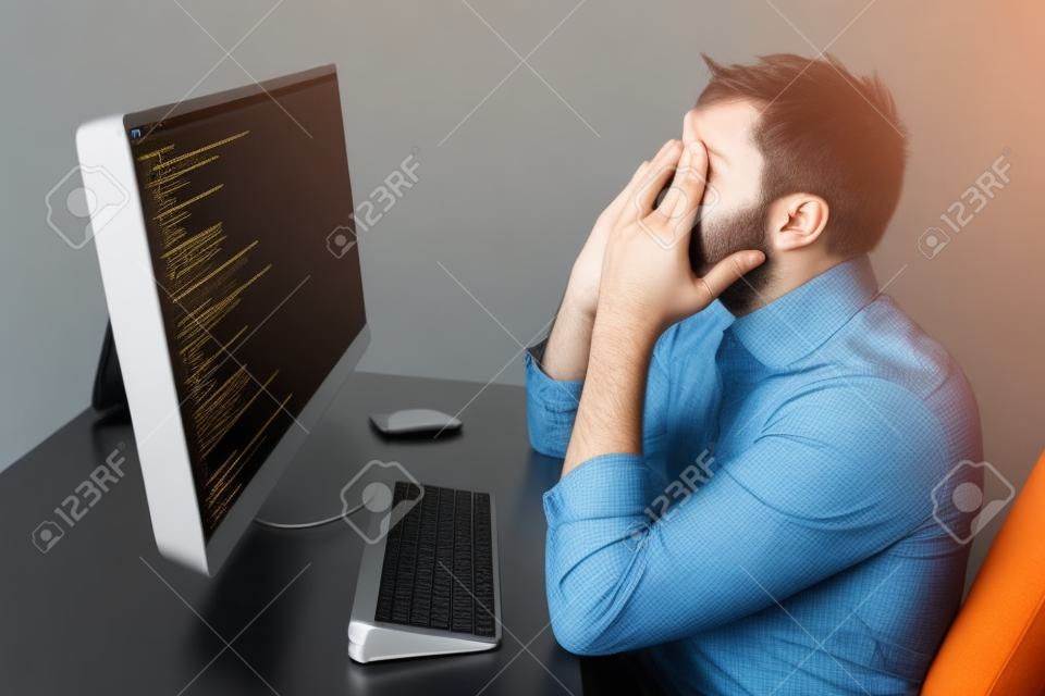 締め切り、技術と人のコンセプト - 悲しい強調ホーム オフィスのコンピューターとソフトウェア開発者