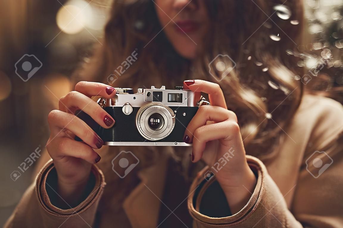 Hipster meisje met retro camera maken foto's in de nacht stad straat
