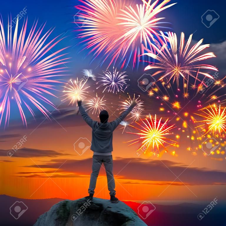 Ein Mann stand am Berg mit offenen Armen auf schönen Urlaub Feuerwerk Hintergrund, Gefühl der Freiheit