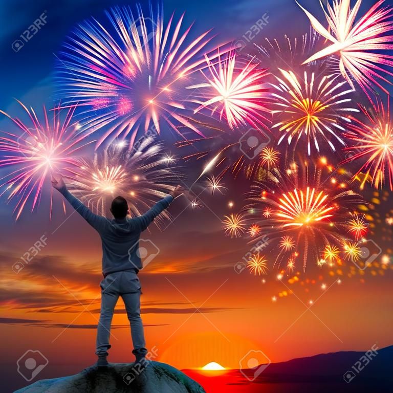 Ein Mann stand am Berg mit offenen Armen auf schönen Urlaub Feuerwerk Hintergrund, Gefühl der Freiheit