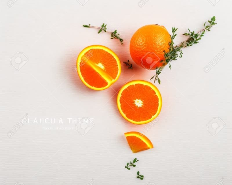 Orange Zitrusfrüchte und Thymian kreatives Layout isoliert auf weißem Hintergrund. Gesundes Essen und Food-Konzept. Zusammensetzung von Früchten und Kräutern. Flache Lage, Draufsicht