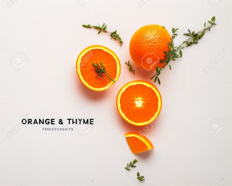 Layout creativo di agrumi e timo arancione isolato su sfondo bianco. Mangiare sano e concetto di cibo. Composizione di frutta ed erbe aromatiche. Vista piana e dall'alto
