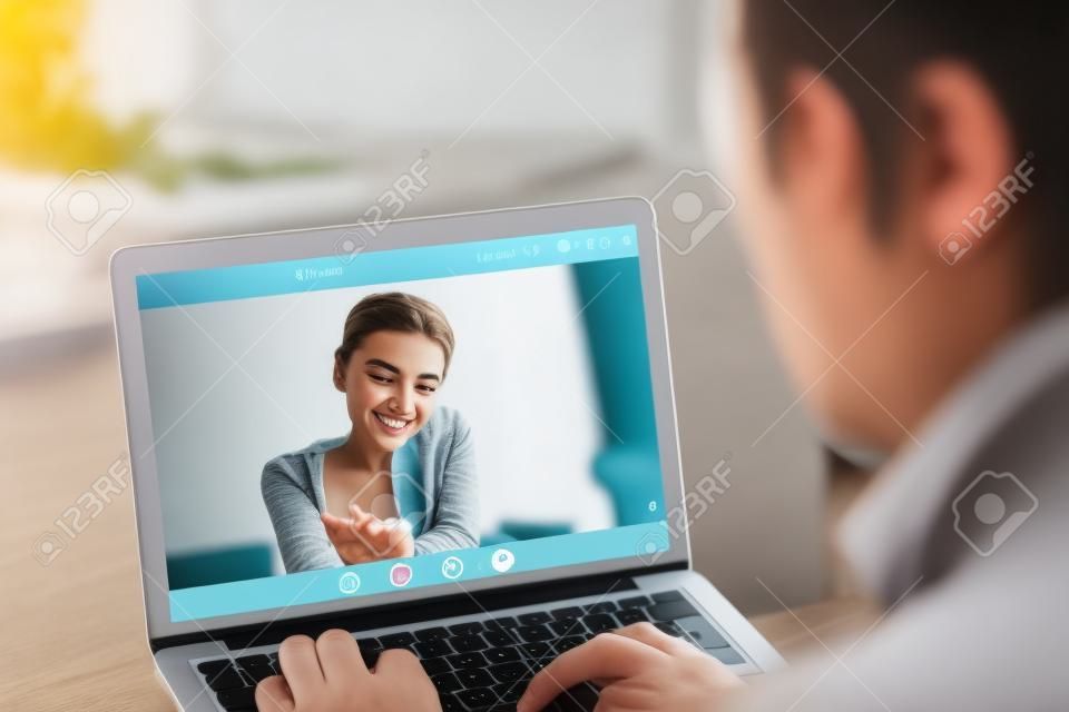 Застенчивая девушка-подросток на видео-вызов с парнем, пара, разговаривающая по видеоконференции приложение, молодая женщина смущена во время виртуального общения с мужчиной, дистанционные отношения, сосредоточиться на экране, закрыть вид сзади