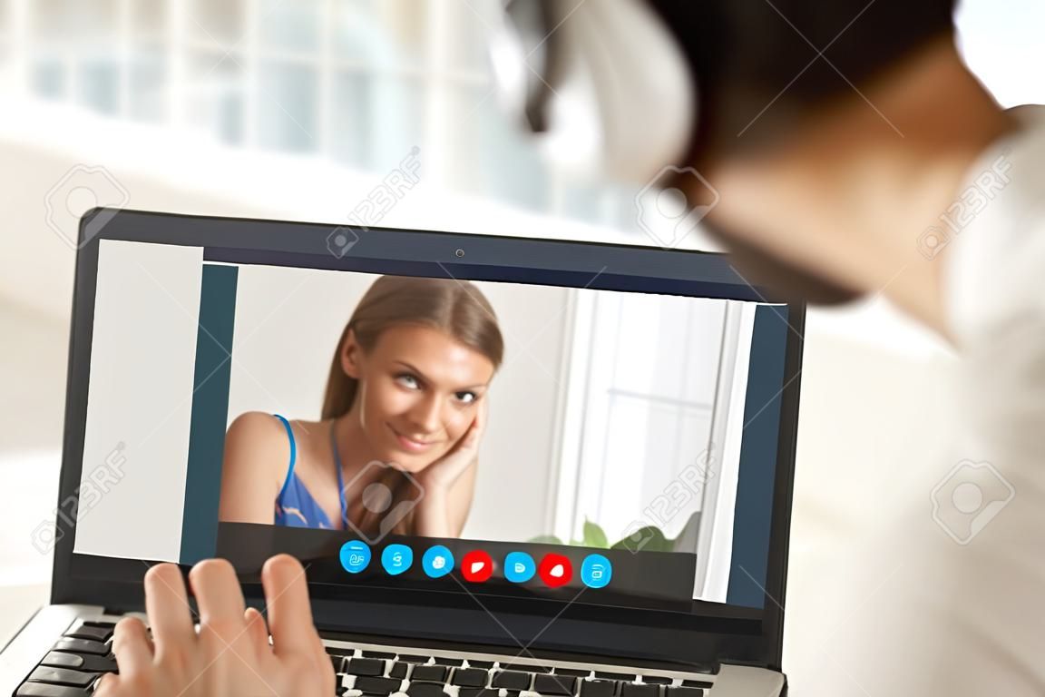 Застенчивая девушка-подросток на видео-вызов с парнем, пара, разговаривающая по видеоконференции приложение, молодая женщина смущена во время виртуального общения с мужчиной, дистанционные отношения, сосредоточиться на экране, закрыть вид сзади