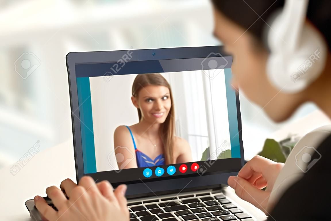 Shy teen girl sur appel vidéo avec un petit ami, couple par l'application par vidéoconférence, jeune femme embarrassée lors du chat virtuel avec l'homme, les relations à distance, se concentrer sur l'écran, fermer la vue arrière