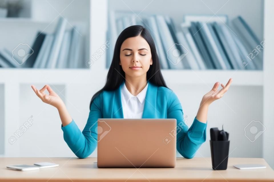Kalme vrouw ontspannen mediteren met laptop, geen stress gratis verlichting op het werk concept, bedachtzame vredige jonge zakenvrouw of studente oefenen ademhaling yoga oefeningen op het werk, kantoor meditatie