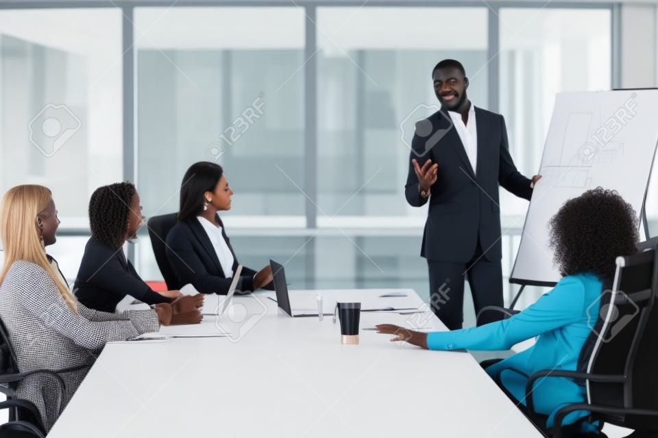 African businessman presenting new project to partners, black coach giving presentation to clients at conference meeting room, dark skinned team leader reporting about work result with whiteboard