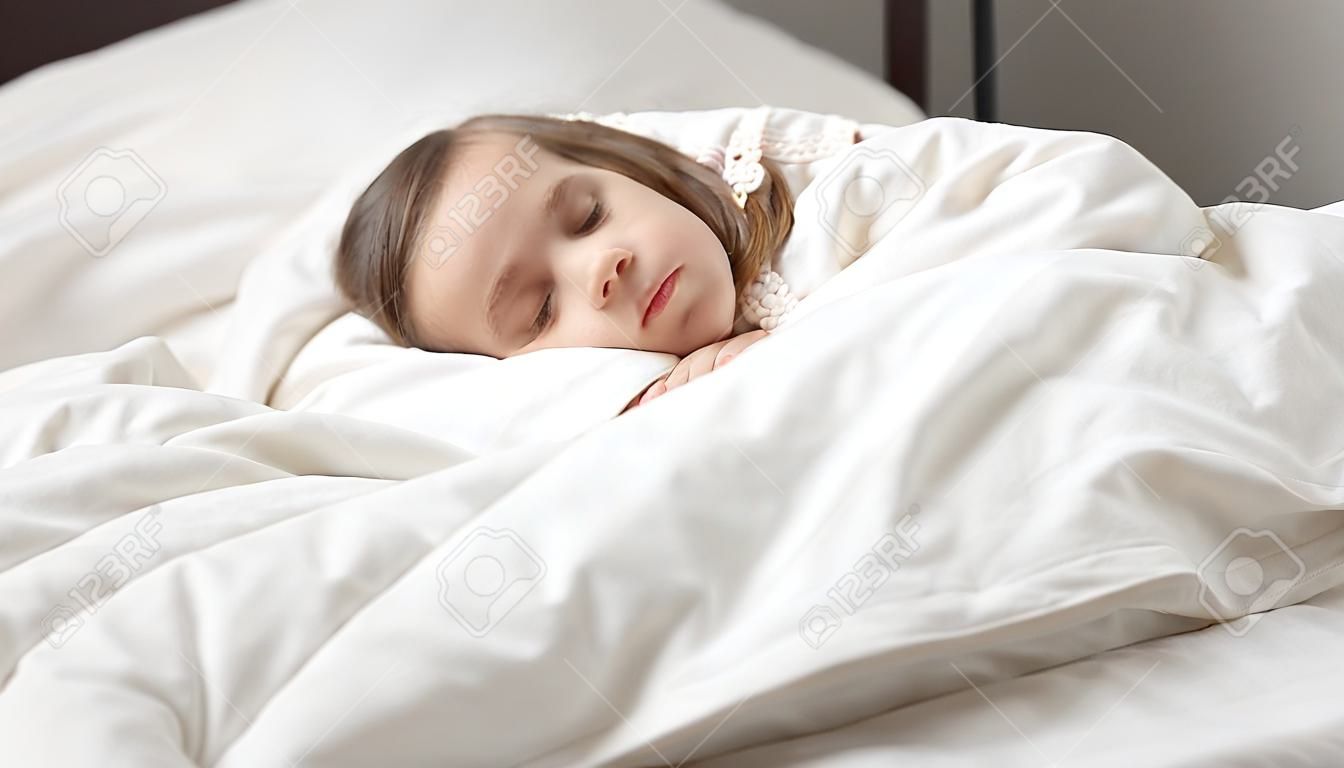 Spokojna urocza córeczka ucina sobie drzemkę. Spokojne dziecko w wieku przedszkolnym dziewczynka pokryte białą kołdrą świeże leżącego w łóżku wygodny materac w sypialni. Wystarczająco zdrowy sen, zzz, dobranoc, koncepcja