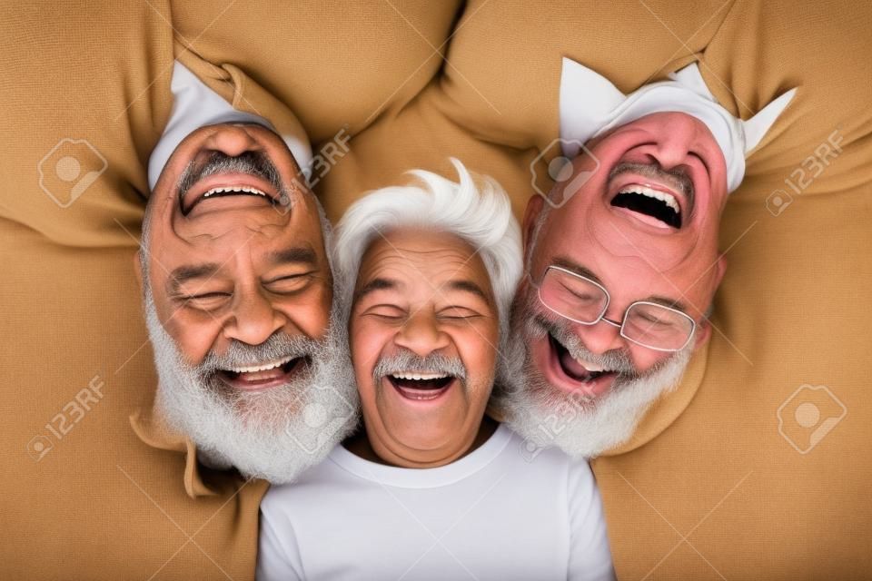 행복한 멀티 3 3세대 가족이 카메라를 바라보며 나란히 누워 웃고 있는 어린 소년 아들 손자, 젊은 성인 아버지와 노부부가 웃고 있는 유대감, 클로즈업 초상화, 위쪽 보기