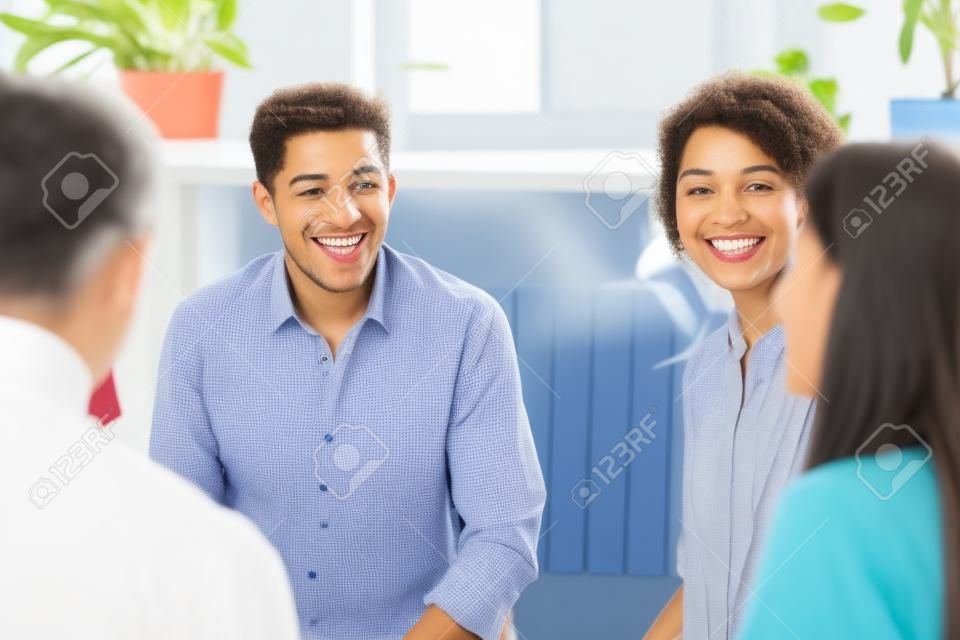 Overjoyed diverse people gather at meeting have fun talking speaking, happy multiracial colleagues patients laugh engaged in teambuilding training or therapy at briefing, help, cooperation concept