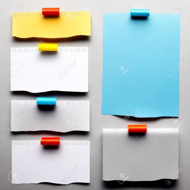 Pieces of torn white blank lined note paper with colorful sticky tape on gray background.