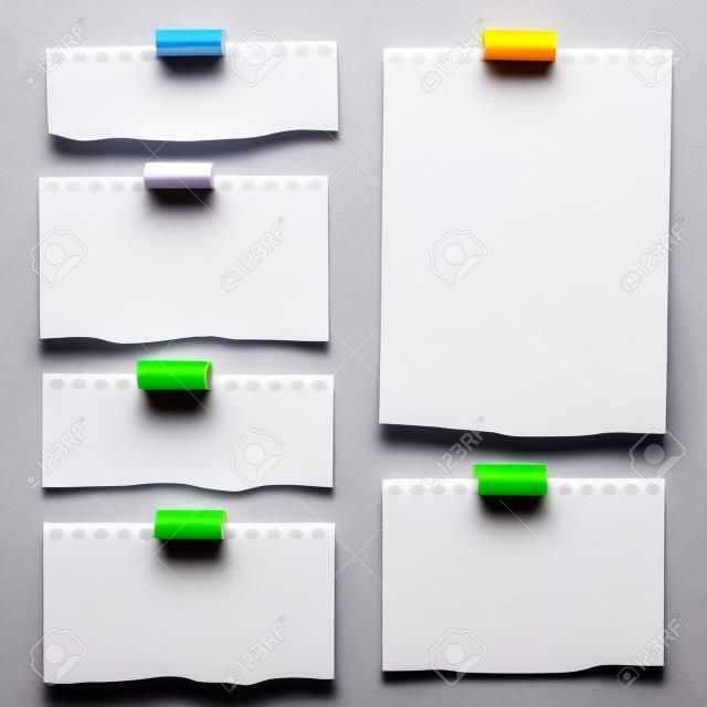 Stukken gescheurd wit wit blanco notitiepapier met kleurrijke plakband op grijze achtergrond.
