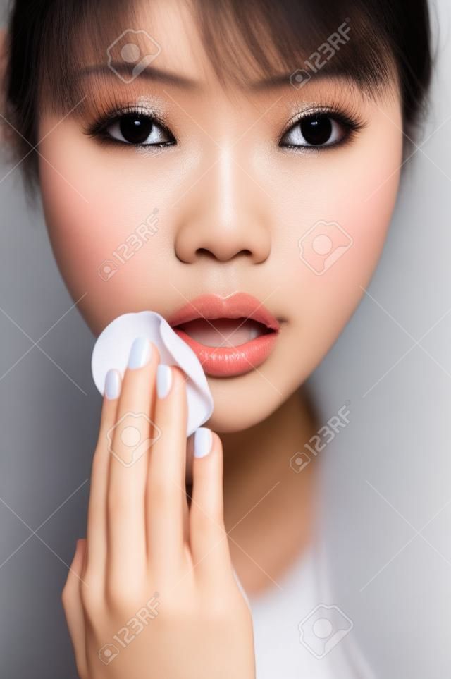 Asian woman removing make-up
