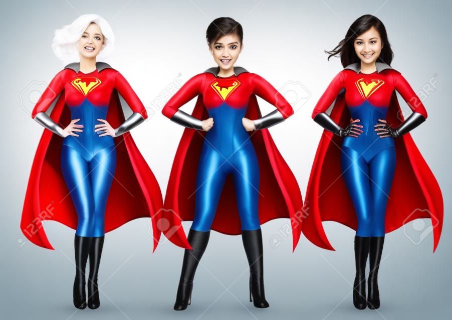 三个穿着超级英雄服装的漂亮女孩双手叉腰站在白色背景下