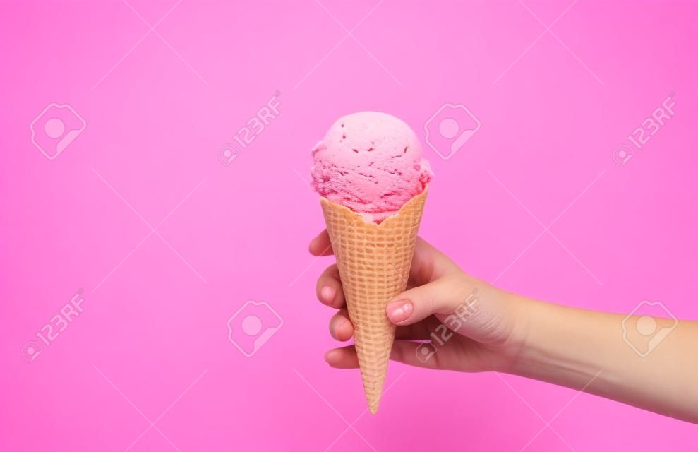 손을 흰색 배경에 딸기 아이스크림 콘을 들고. 웨이퍼 컵에 딸기 아이스크림.