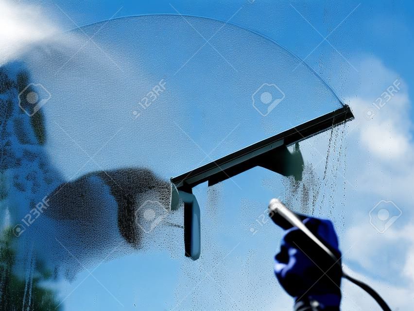 用刮刀洗一個窗口，窗戶清潔劑