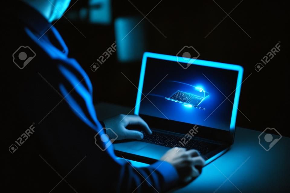 Tarde en la noche la adicción a Internet o trabajando hombre finales usando la computadora portátil en un escritorio en la oscuridad