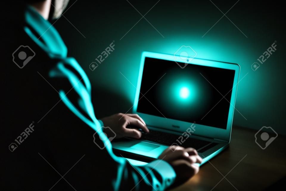 Late night Internet-Sucht oder arbeiten spät Mann mit Laptop an einem Schreibtisch in der Dunkelheit