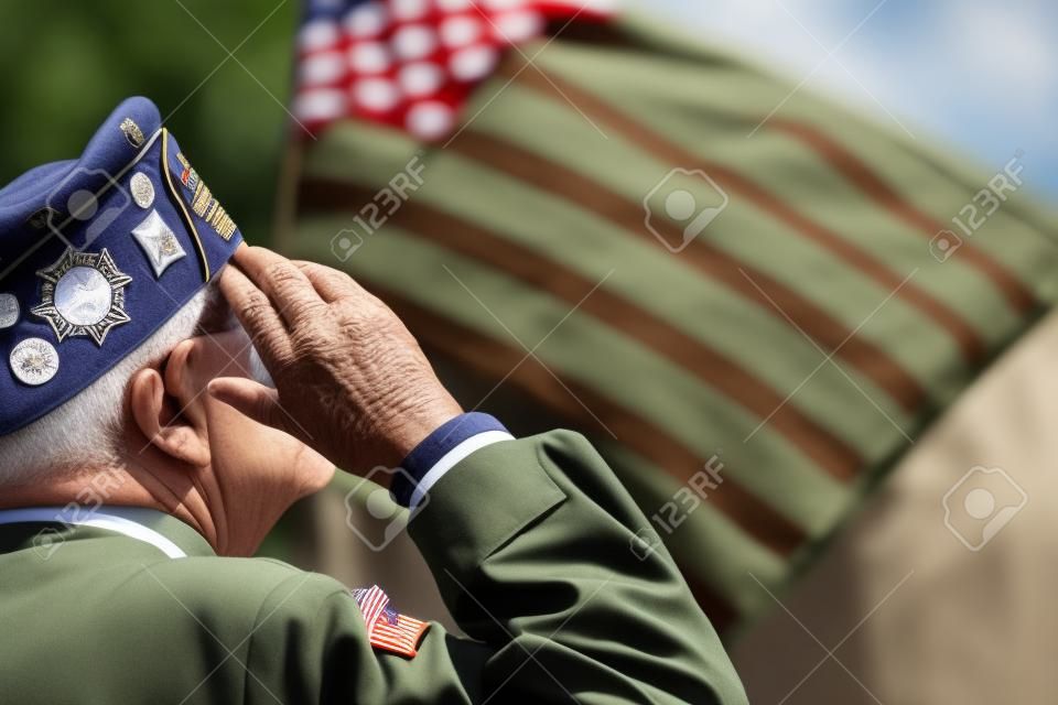 Ветеран является отдавая честь перед американским флагом.